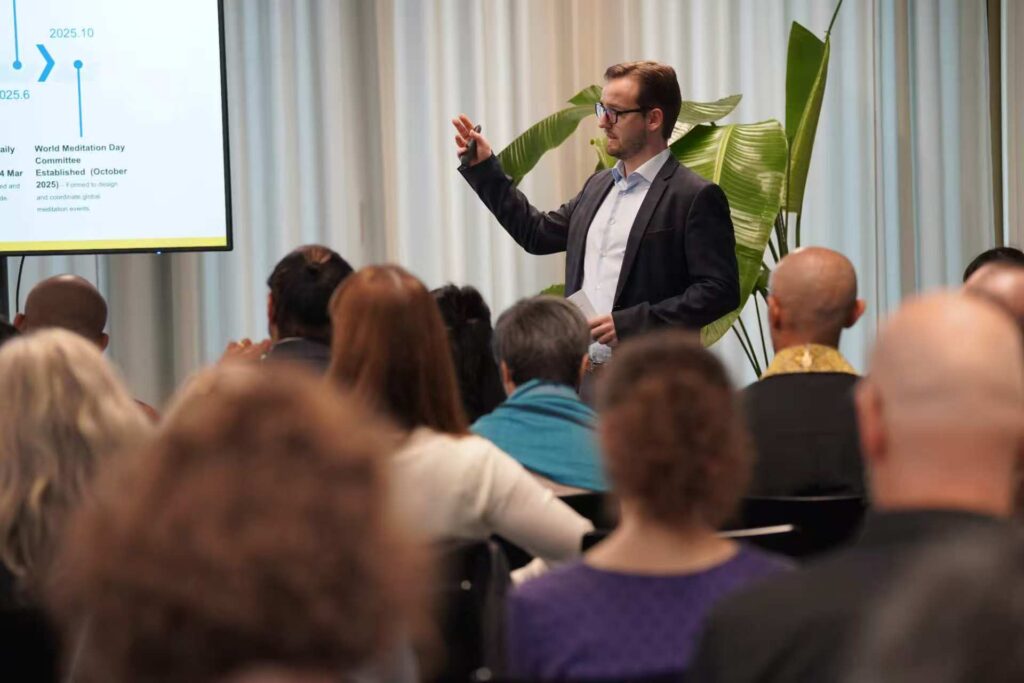 A speaker presents to a seated audience at the AI and Mindfulness forum.