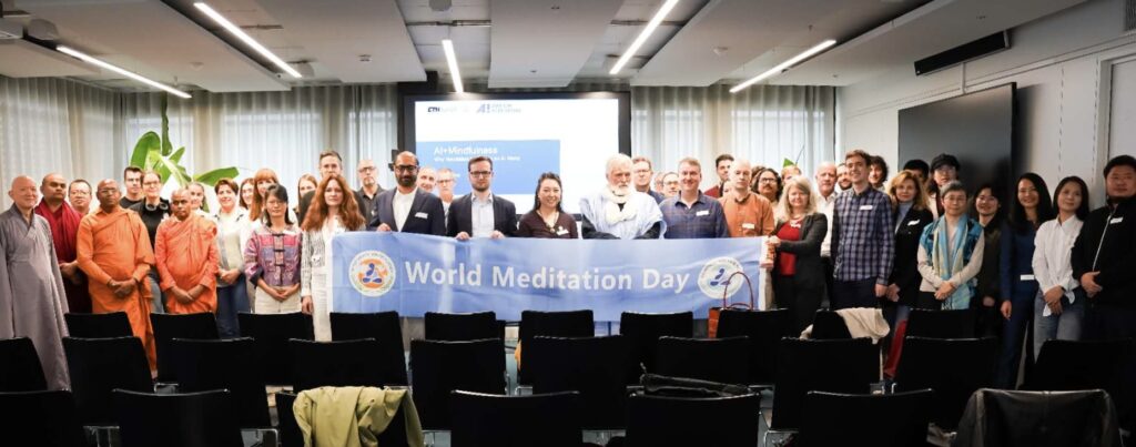 AI and Mindfulness forum participants gather behind a World Meditation Day banner.